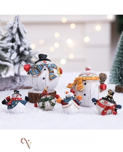Detailed view of assorted resin snowman figurines with colorful scarves and wood-like bases