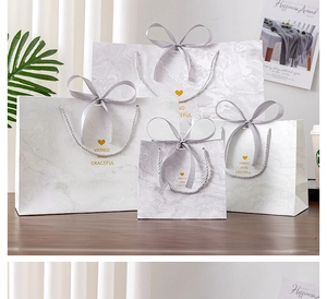 Set of marble pattern gift bags with silk handles and gold heart details in four sizes