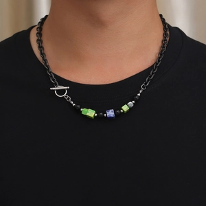 Nahaufnahme einer Retro-Titanstahlkette mit bunten Würfeln am Hals eines Models