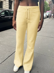 Close-up of pale yellow high-waisted yoga pants with functional drawstring waist detail
