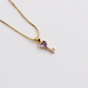 Detail showing gold key pendant with purple heart gemstone and micro-set zircons on box chain