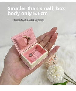 Close-up of pink book-shaped jewelry box with ring slot and magnetic closure detail