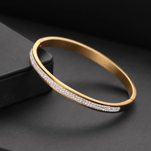 Gold-plated stainless steel oval bangle featuring double-row cubic zirconia inlay