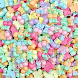 Macro detail of mixed macaron color resin bow and star charms for nail art and crafts