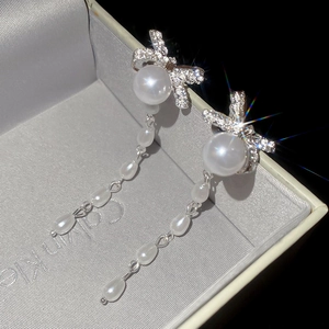 Close-up of bow knot pearl tassel earrings with micro-inlaid diamonds on silk