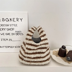 Détail d'un sac à main pelucheux rayé avec doublure à carreaux dans un décor de thé