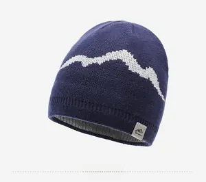Detail of navy knit beanie with white mountain pattern and stitched hem brand label