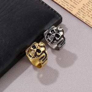 Detail of gothic hip hop skull and snake wrap rings in gold and vintage silver finish