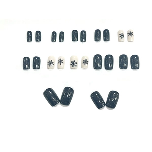 Short square press-on nails with dark grey glitter and white snowflake patterns