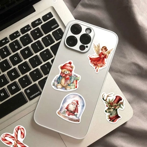 Close-up of festive Christmas PVC stickers featuring Santa and reindeer on a mobile phone case