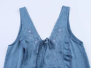 Vue détaillée du haut sans manches bleu gris avec broderie florale et décolleté en V à lacets