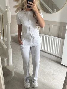 Detail view of grey ribbed knit set featuring button-up t-shirt and drawstring pants