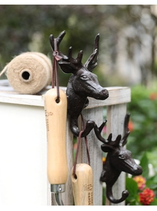 Detail of vintage cast iron deer head wall hooks showing rustic antler texture and finish
