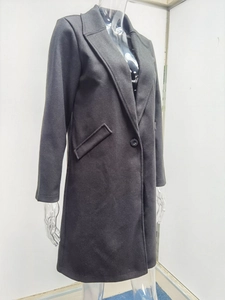 Detail of a dark gray lapel wool coat featuring single-breasted buttons and side pockets