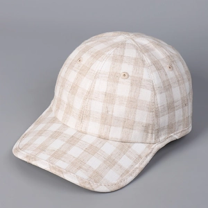 Close-up of premium beige plaid linen fabric and fine stitching on the baseball cap