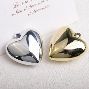 Detailed view of heart-shaped gold and silver metallic acrylic pendants on a textured background