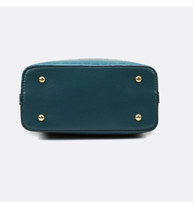 Detail view of the crocodile embossed handbag base with protective gold metal feet