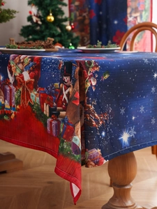 Detail of Christmas tablecloth featuring nutcracker and reindeer patterns on a wooden table