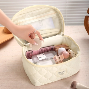 Off-white quilted cosmetic bag with large capacity for travel storage on vanity