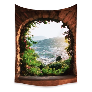 Detail of bohemian tapestry featuring a coastal landscape through a brick stone window arch