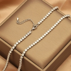 Close-up of silver tennis necklace with white zircons on luxury silk jewelry box