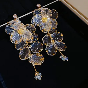 Elegant acrylic flower tassel earrings with clear resin petals and golden accents