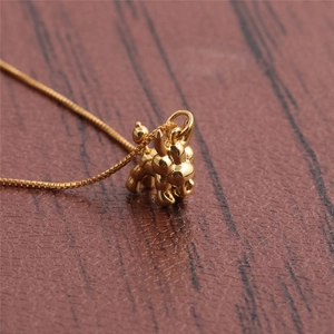 Elegant gold plated balloon dog pendant necklace on a rustic wooden background surface