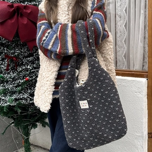 Detail of dark gray faux fur tote bag with white polka dots and zakka label