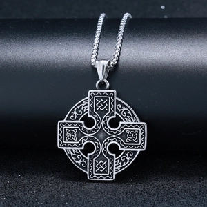 Macro view of vintage Celtic cross pendant in stainless steel with intricate carvings