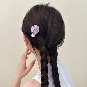 Barrette élégante rose violette avec perle sur la coiffure tressée d'un modèle