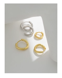 Detailed view of minimalist irregular round hoop earrings in both gold and silver finishes