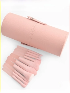Close-up of 10-piece peach powder makeup brush set with a textured cylinder storage case