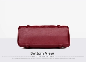 Detail view of burgundy leather handbag base showing fine stitching and braided accents