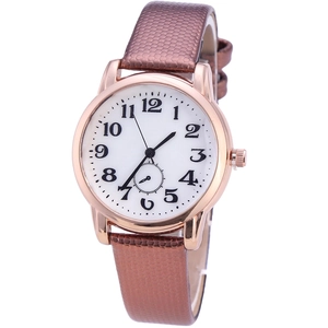 Detail view of white watch face with black numerals and a rose gold bezel on brown leather strap