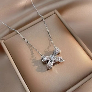 Elegant silver bow necklace with sparkling crystals in a jewelry box for women