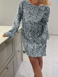 Dettaglio di un elegante abito corto in paillettes argento con maniche lunghe e trama lucida