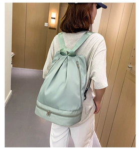Detail view of light green oxford swim bag showing the bottom shoe compartment and straps