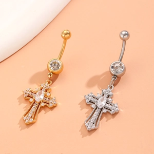 Macro detail of cross belly rings with gold and silver finishes and zircon crystals