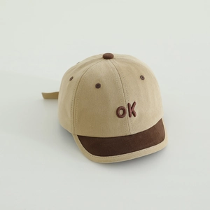 Detail der OK-Stickerei auf khakifarbener Baby-Baseballkappe mit kurzem Kontrastschirm