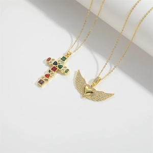 Golden Angel Love necklace set featuring a colorful gemstone cross and winged heart pendant