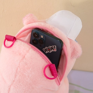 Detail of the pink plush Capybara backpack zipper opening showing storage for a phone