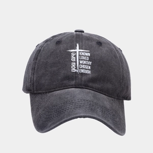 Detail of vintage washed grey baseball cap with white cross and inspirational text