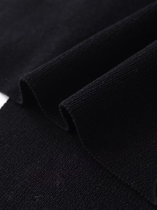 Macro view of soft black knitted fabric texture with elegant wavy folds on halter top