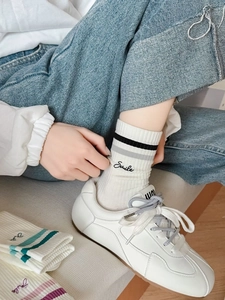 Detail of white cotton sports socks with smile embroidery and casual striped design
