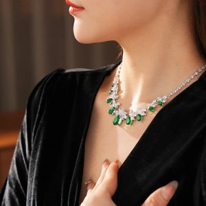 Gros plan du collier fleur élégant avec zircons zircons émeraude et clairs sur un mannequin