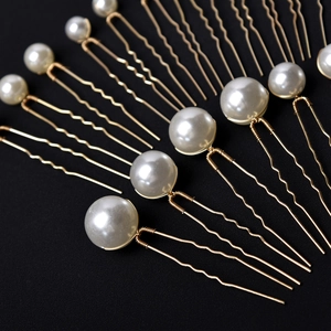 Elegant bridal hair pins set with white pearls and gold metal U-shaped forks on black