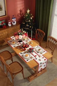 Close-up of Christmas table runner with tassels, red snowflake patterns and holiday motifs