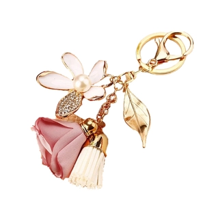 Pink floral keychain with satin rose, white tassel, and gold leaf charm for bags