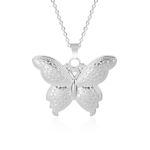 Détail macro du pendentif papillon évidé en acier inoxydable argenté poli brillant