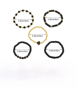 Dettaglio del set di 5 braccialetti di perline nero e oro con dischi in argilla e cuori
